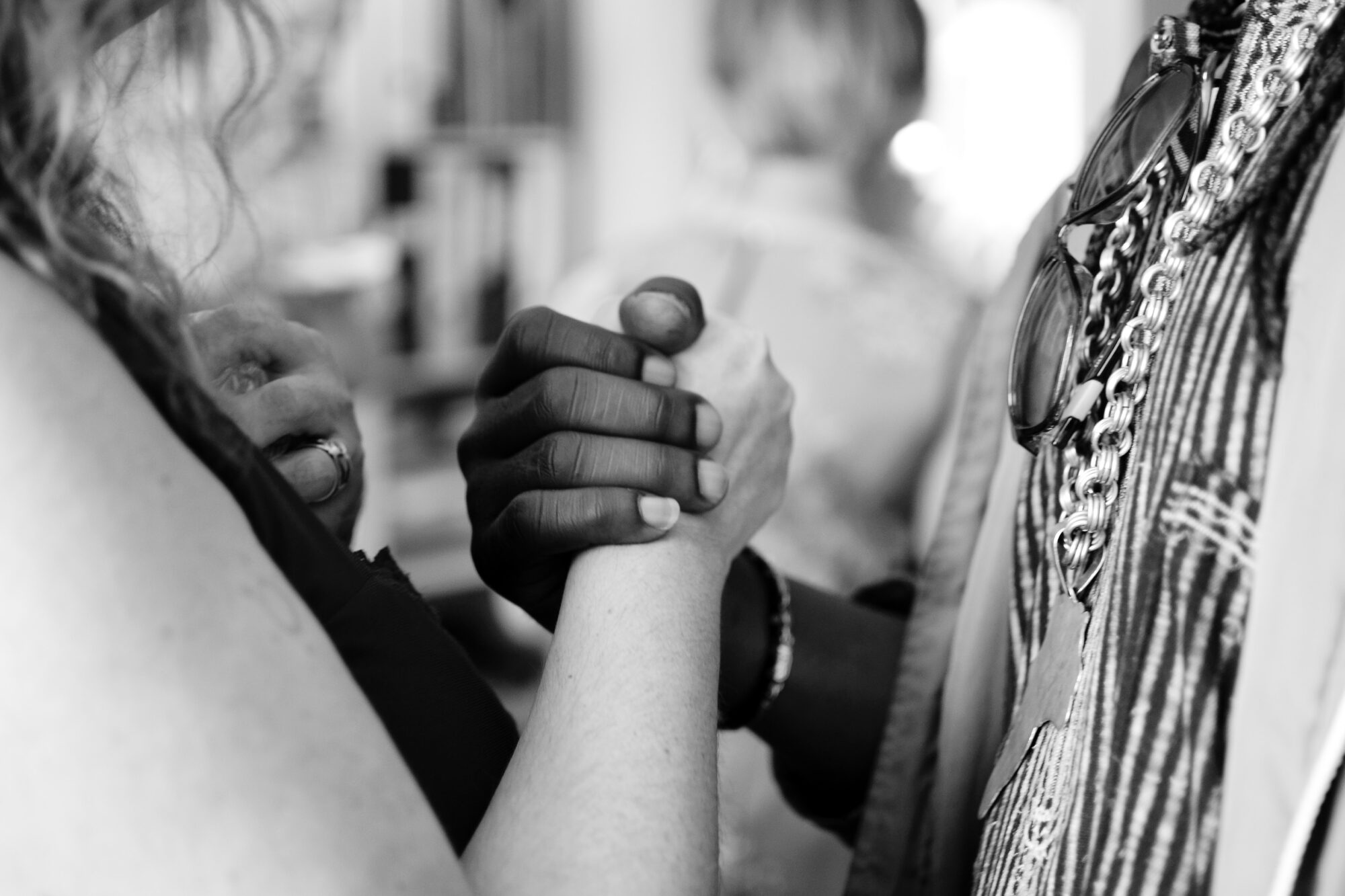 Black and white photograph of a unionized holding hands between a white female and and a black male persons.