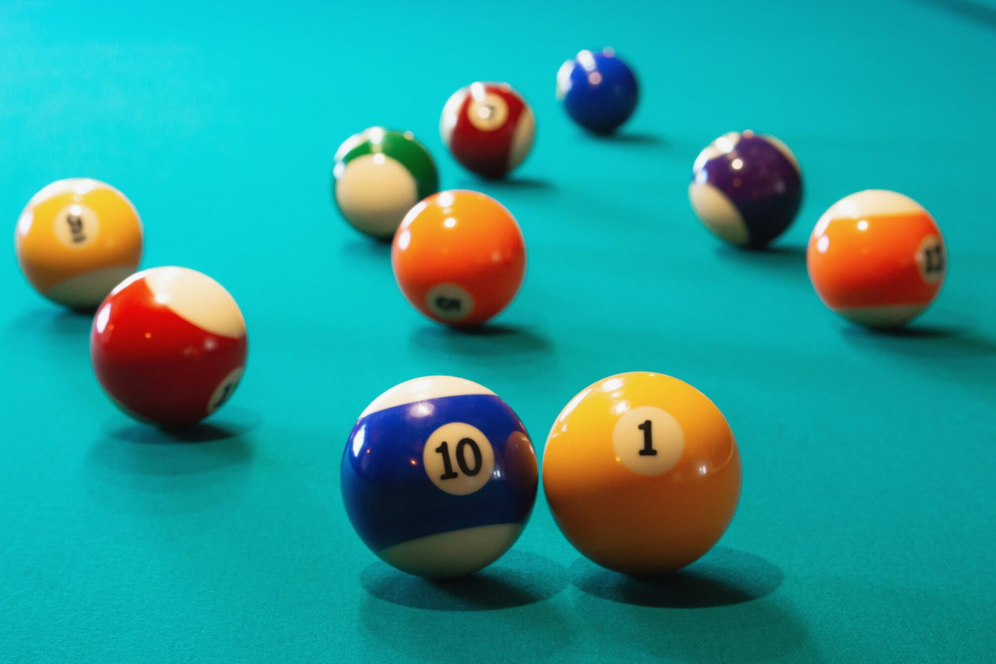 On the billiard table coloured and numbered balls spaced around.