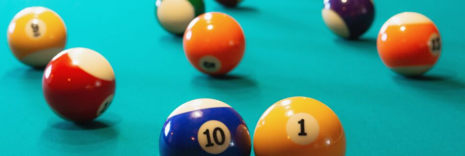 On the billiard table coloured and numbered balls spaced around.